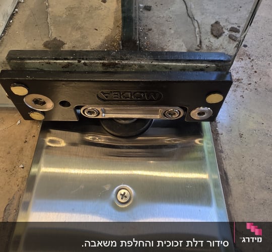 תקריב של מנגנון תחתון ומחזיר שמן רצפתי לדלת זכוכית